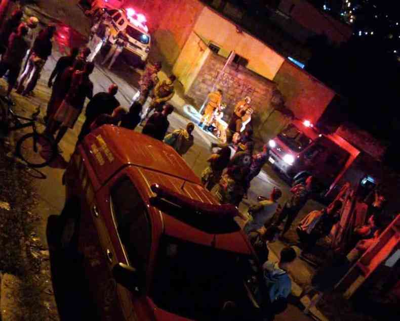 Viatura do Corpo de Bombeiros estacionada na Rua Urupema, em Santa Luzia. Militares resgatam idoso de dentro de um bueiro. Populares acompanham a operao.