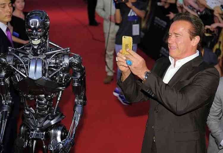 Robô do filme 'O Exterminador do Futuro' ao lado do ator Arnold Schwarzenegger em tapete vermelho 