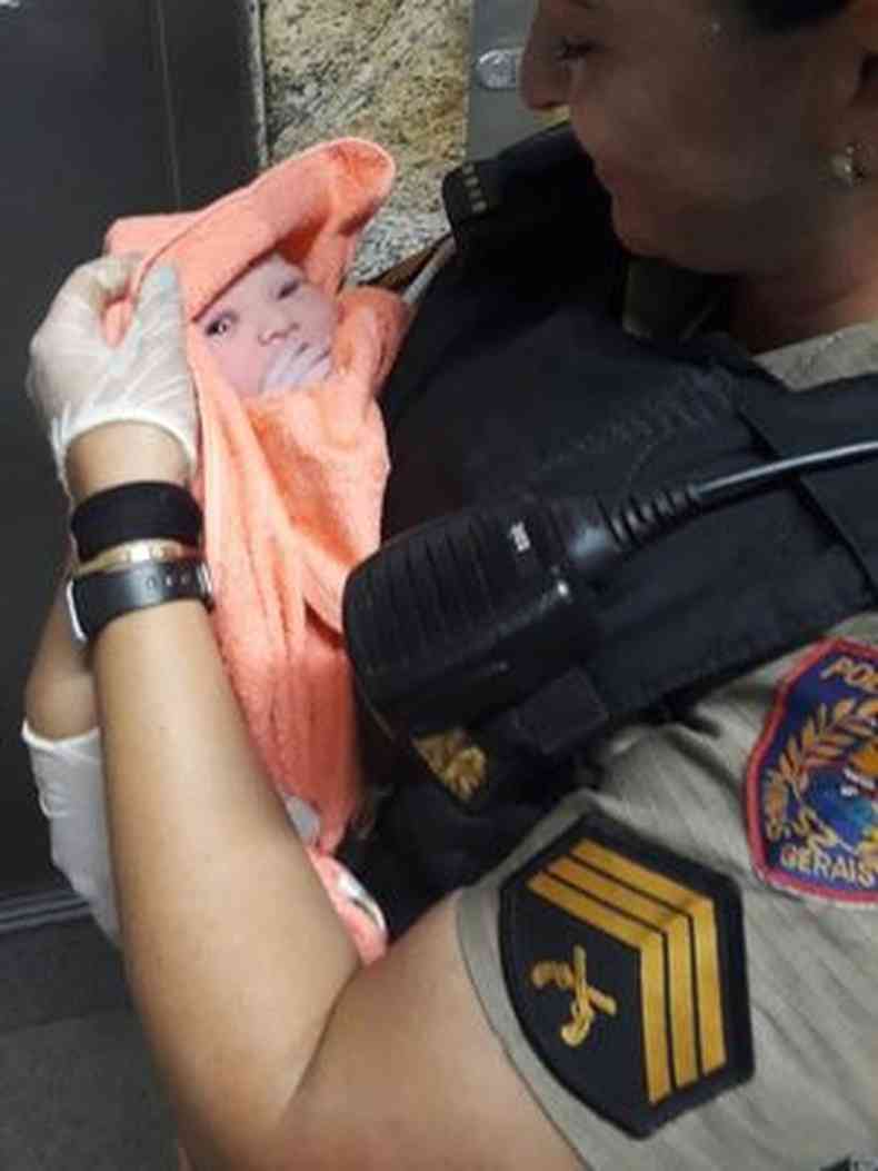 A pequena Elo nos braos da sargento Gisele Bertucci, que ajudou no parto (foto: Polcia Militar/ Divulgao)