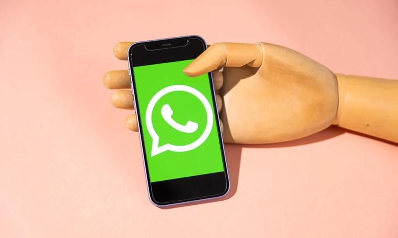 Mo segurando um celular com o smbolo do whatsapp