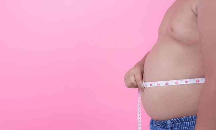 menino obeso medindo a barriga com fita mtrica