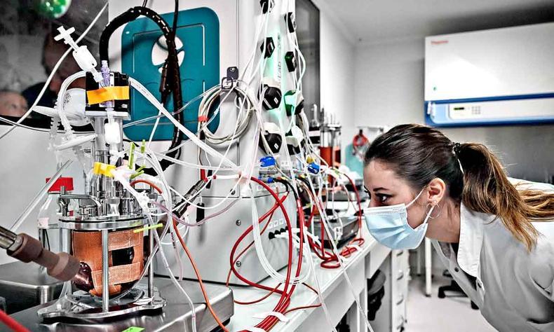 Cientista observa aparelho em laboratrio, com vrios fios  sua frente