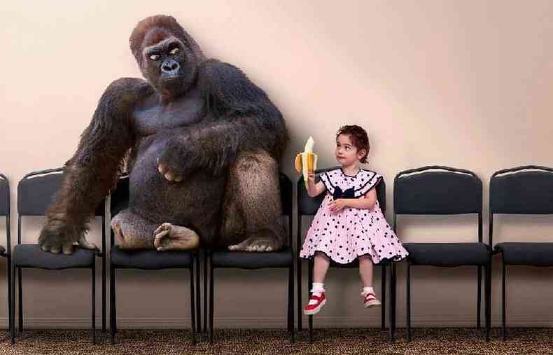 Garota oferecendo banana para um orangotango