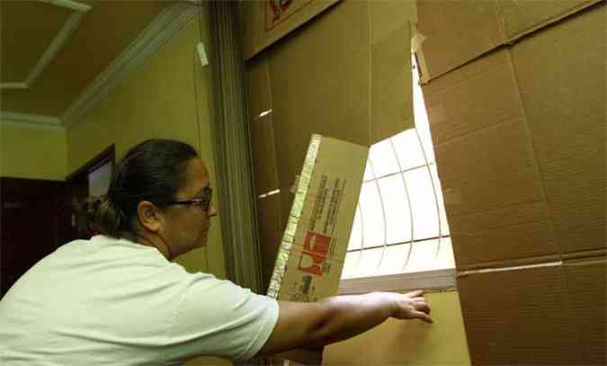 Senita Alves, moradora do Antares, mostra um tapume de papelo improvisado 