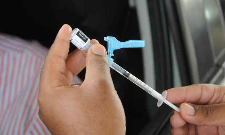 Enfermeira segurando seringa com vacina da Pfizer