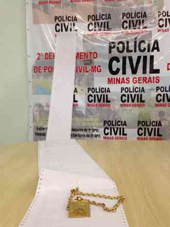 Polcia mostra ficha criminal do suspeito, juntamente com uma corrente de ouro que era usada por ele para demonstrar o poder aquisitivo(foto: Edsio Ferreira/EM/DA Press)