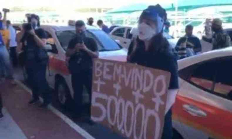 Jovem carregava faixa que lembrava o nmero de mortos por COVID-19 no Brasil(foto: Redes Sociais/Reproduo)