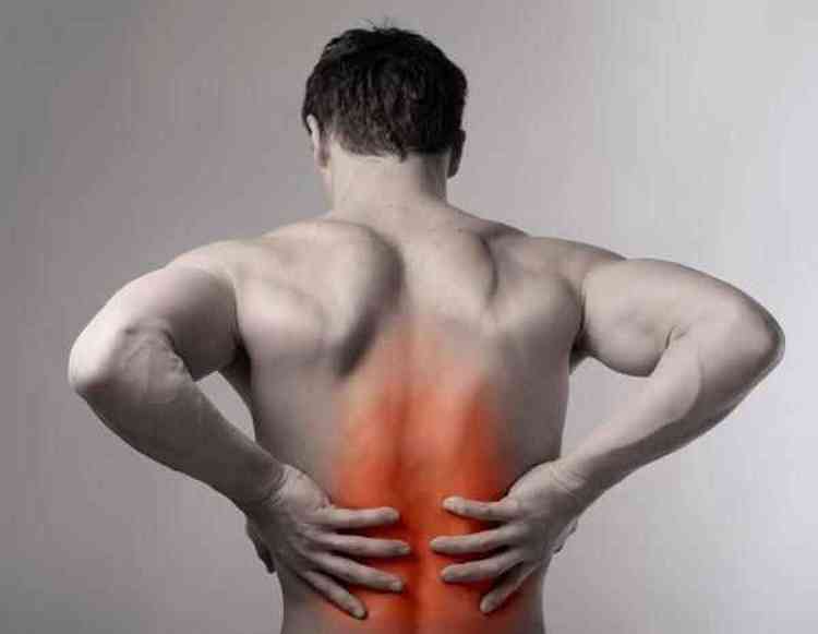 Homem de costas com dores nos rins com as duas mos sobre as costas com destaque vermelho em cores artificiais no local