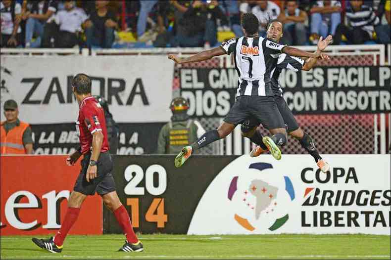 J e Ronaldinho Gacho comemoram o gol da vitria sobre o Zamora, na Venezuela, por 1 a 0. No Independncia, no jogo de mesmo placar, com gol do camisa 7 novamente(foto: LEO RAMIREZ/AFP %u2013 11/2/14volta, o )