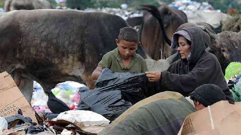 690 milhes de pessoas passaram fome em 2019, de acordo com a FAO. Na foto, uma mulher e uma criana procuram comida no meio do lixo(foto: Getty Images)