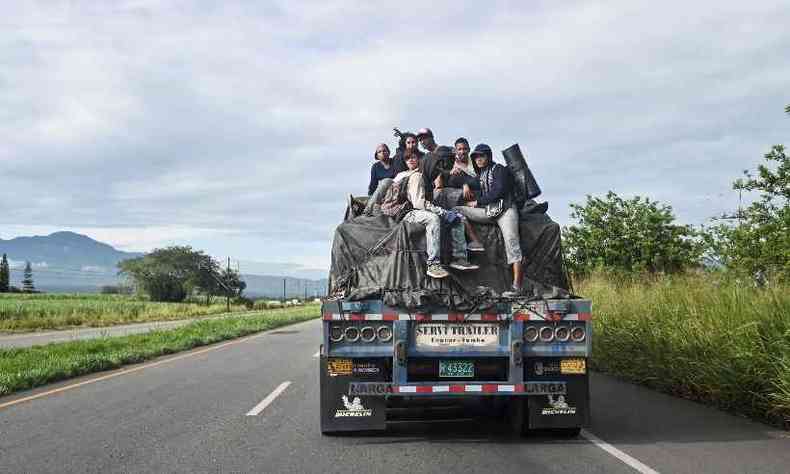 Migrantes venezuelanos pegam carona em caminho na estrada Panamericana, na Colmbia(foto: Luis ROBAYO / AFP)