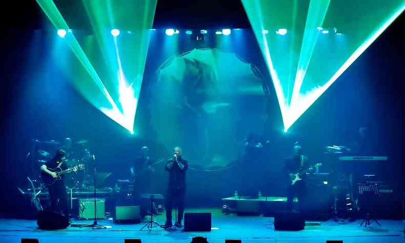 Vestidos de preto, cantores do musical 'Pink Floyd - The wall live' se apresentam em palco com jogo de luzes verdes e azuis