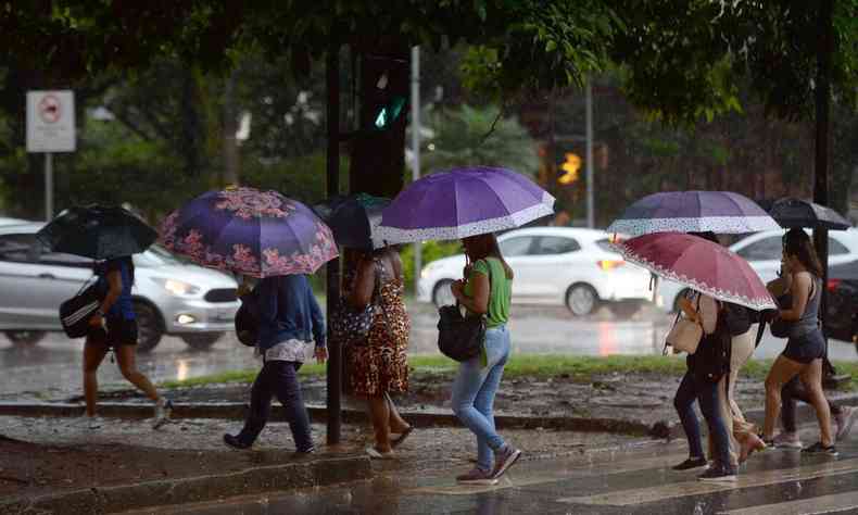 Rua de BH com chuva, pessoas andando com guarda-chuva