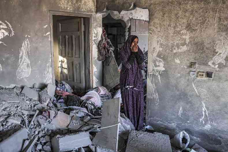 Uma mulher reage numa casa fortemente danificada aps o bombardeamento israelita em Rafah, no sul da Faixa de Gaza, na quinta-feira. Os ataques se somam  falta de comida, gua e energia, itens raros no local