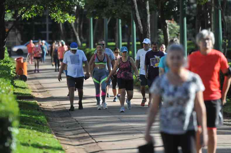Pessoas caminham na praça da Liberdade, em Belo Horizonte, sem máscara