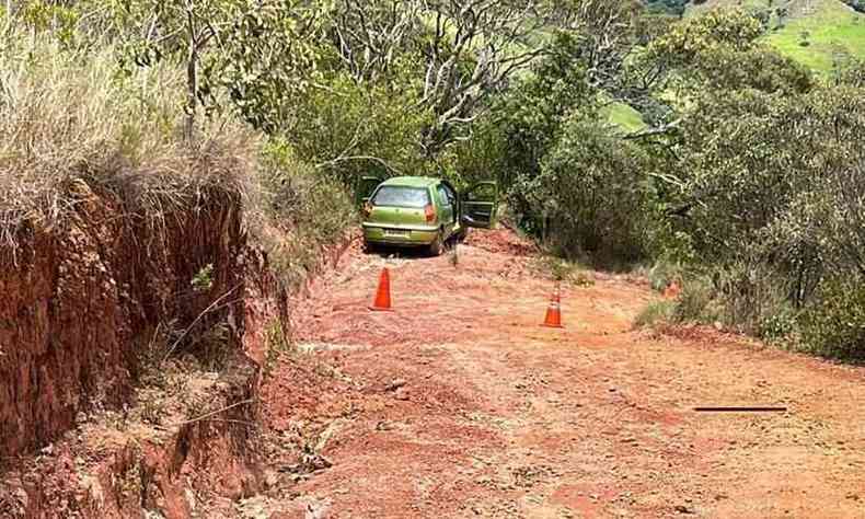 carro verde no meio de uma estrada rural