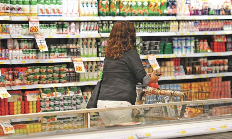 Consumidora faz compras de alimentos em supermercado