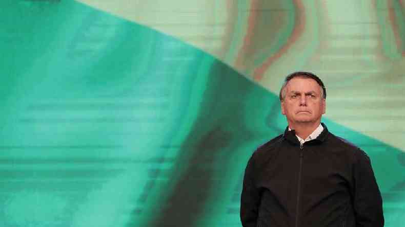 Jair Bolsonaro diante de tela verde e amarela