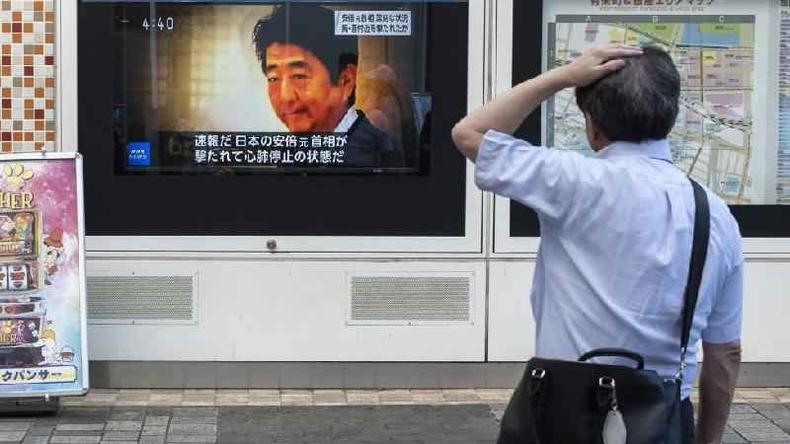 O crime choca um país onde a violência contra políticos e o uso de armas de fogo são extremamente raros(foto: Getty Images) Homem assiste noticia sobre Abe.