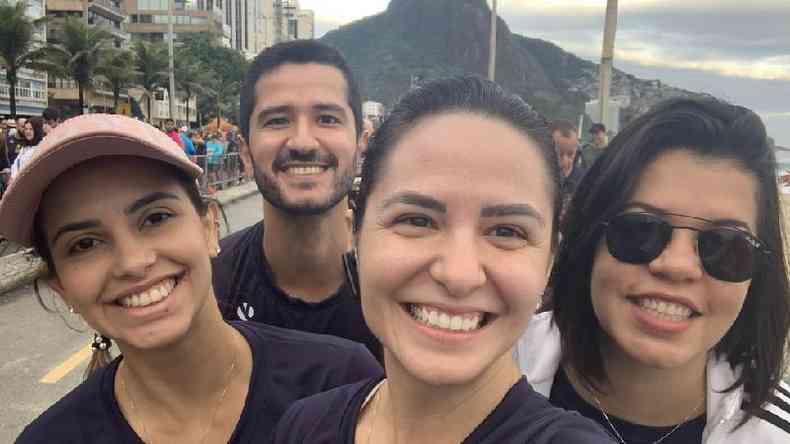 Lsia e mais trs amigos na orla do Rio de Janeiro, sorrindo para selfie