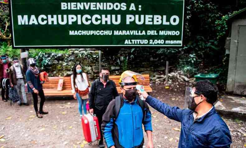 Visitantes tero de passar por medio de temperatura para entrar nas runas de Machu Picchu