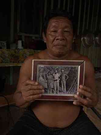 Cacique segura foto onde se veem indigenas e o etnologo Franz Caspar