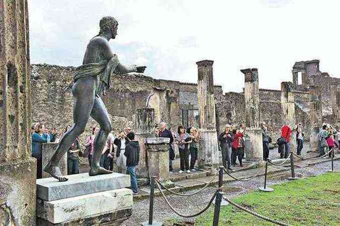 Turistas caminham pelas ruas de Pompeia: a cidade, destruda pelo Vulco Vesvio em 79 a.C.,  uma rica fonte de informaes sobre o cotidiano da antiguidade(foto: (Roberto Salomone/AFP - 27/10/11))