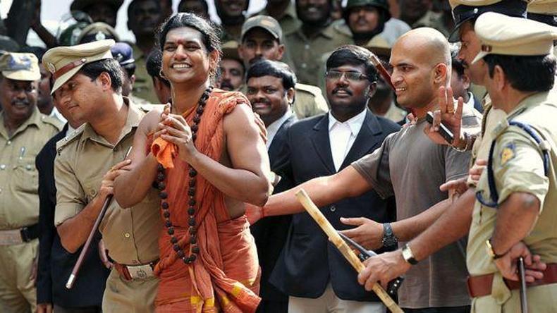 Nithyananda Paramashivam sorrindo enquanto  levado por policiais