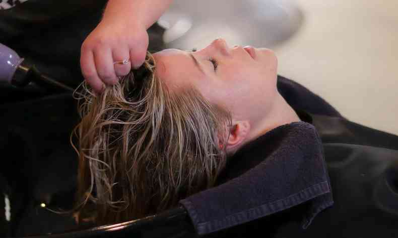 mulher tendo o cabelo lavado no salo de beleza