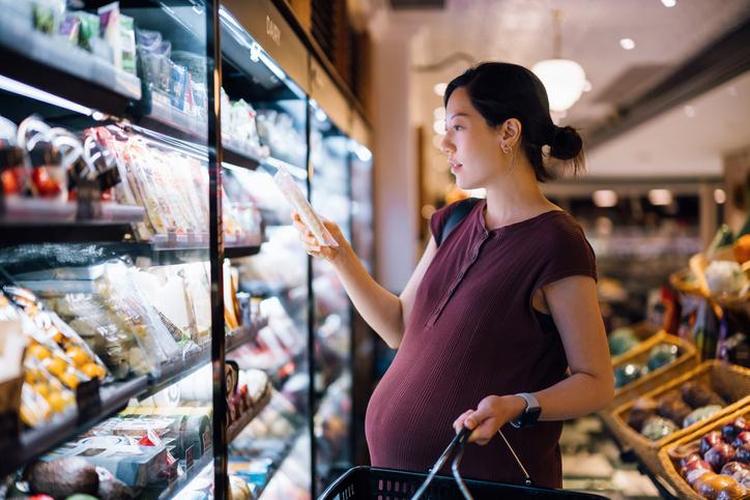 Mulher grvida olhando produto em supermercado