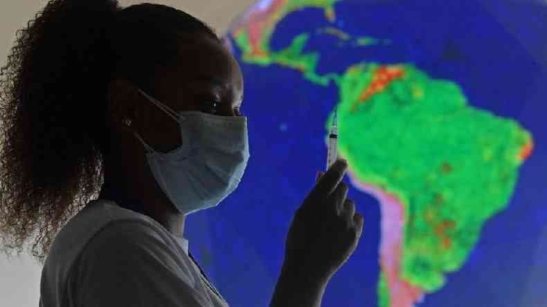 Enfermeira com mscara segurando seringa, com mapa do Brasil atrs