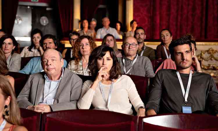 Os atores Wallace Shawn, Gina Gershon e Louis Garrel esto sentados na plateia de um cinema na cena do filme 'O festival do amor'