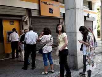 Gregos fazem fila para caixa eletrnico depois que bancos fecharam as portas e limitaram os saques (foto: AFP PHOTO / ARIS MESSINIS )