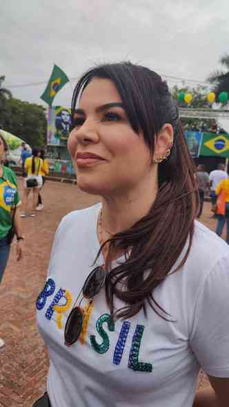 Daniela Linhares com cabelos presos, uma blusa branca escrita Brasil em verde e amarelo