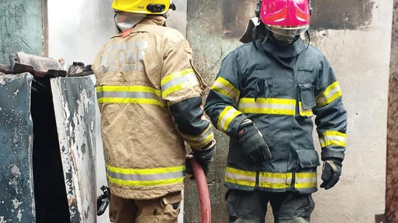 Bombeiros realizam o rescaldo no interior da residncia danificada pelo incndio em Braspolis