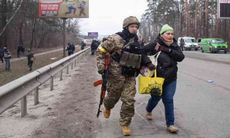 Militar ucraniano ajuda mulher a fugir de regio sob ataque russo