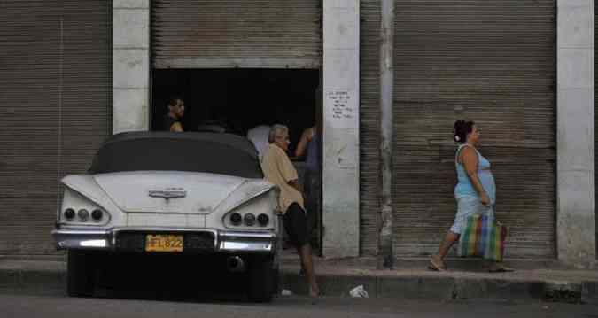 Moradores aguardam atendimento do lado de fora de uma loja de alimentos racionados pelo Estado em Havana (foto: REUTERS / Desmond Boylan (03/11/2012))