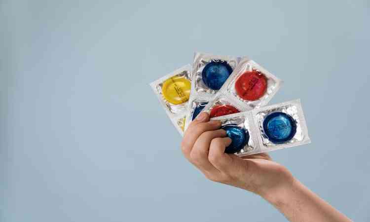Mo segurando preservativos coloridos