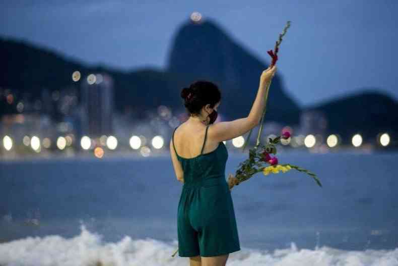 Mulher joga flores no mar 