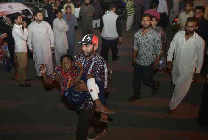Jovem ferido  carregado depois do atentado(foto: ARIF ALI / AFP)