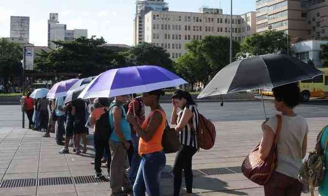Passageiros  espera de nibus na Praa da Estao, em BH, usam guarda-chuvas para se proteger do sol(foto: Tulio Santos/EM/D.A. Press)
