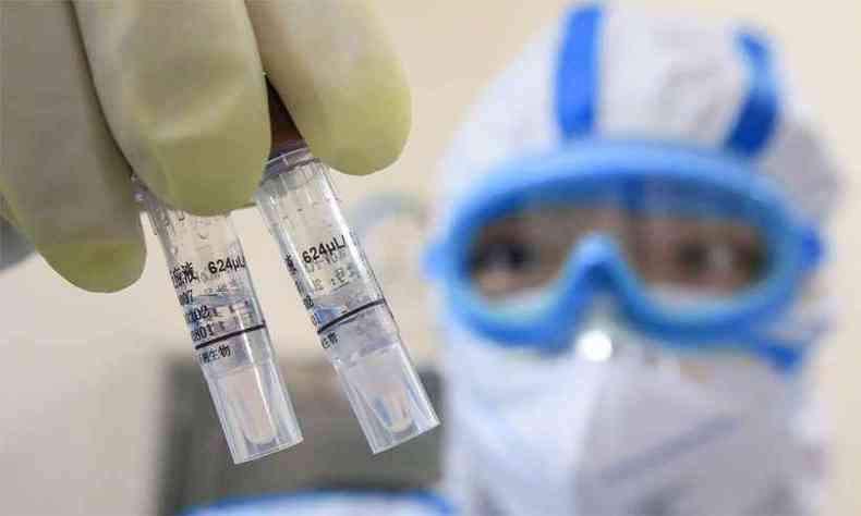Na China, tcnico de laboratrio segura amostras do vrus(foto: China OUT / AFP / STR )