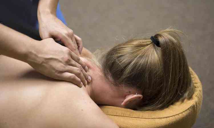 mulher recebendo massagem no ombro