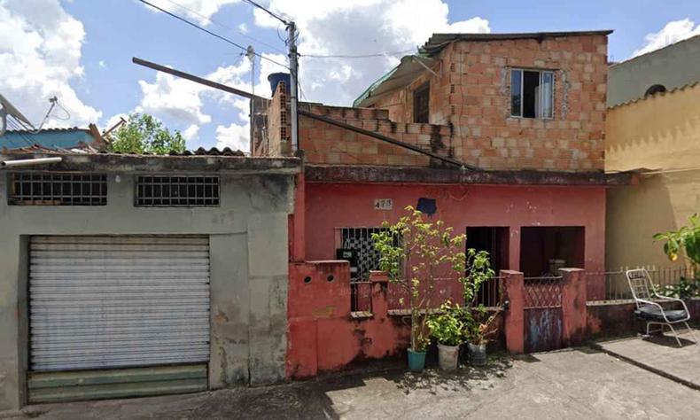 Um porto cinza na esquerda e uma casa rosa de dois andares na direita, casa da vtima