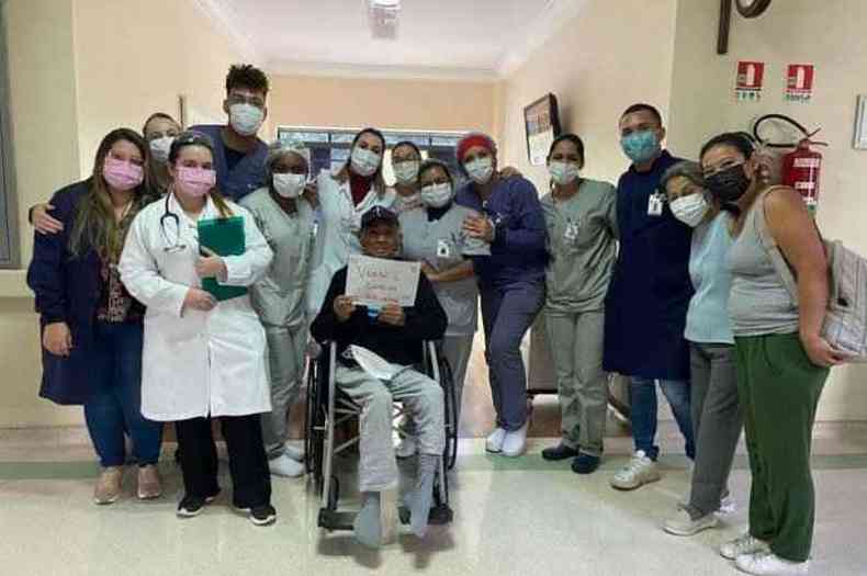 Profissionais da sade posam em foto com paciente que recebeu alta de hospital 