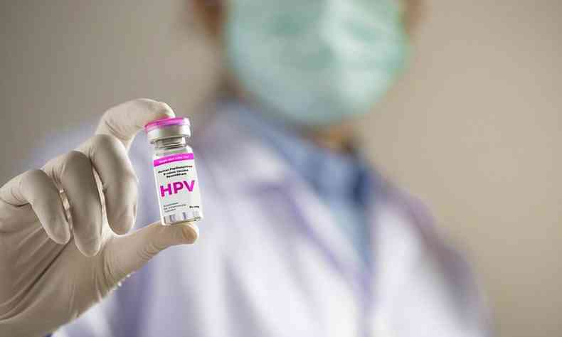 Pessoa com luvas segura frasco de vacina contra HPV