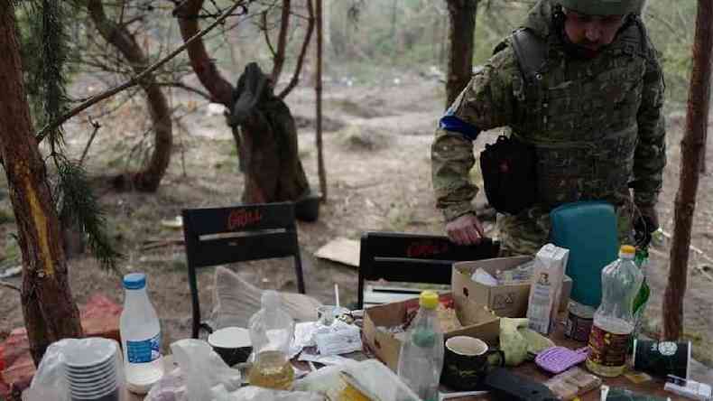 Soldado ucraniano examina as coisas deixadas para trs por tropas russas