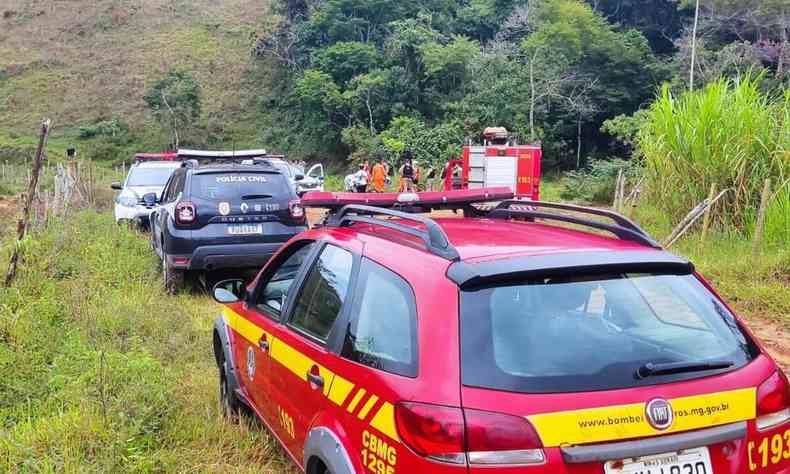 Viaturas do Corpo de Bombeiros e da polcia em estrada de terra. 