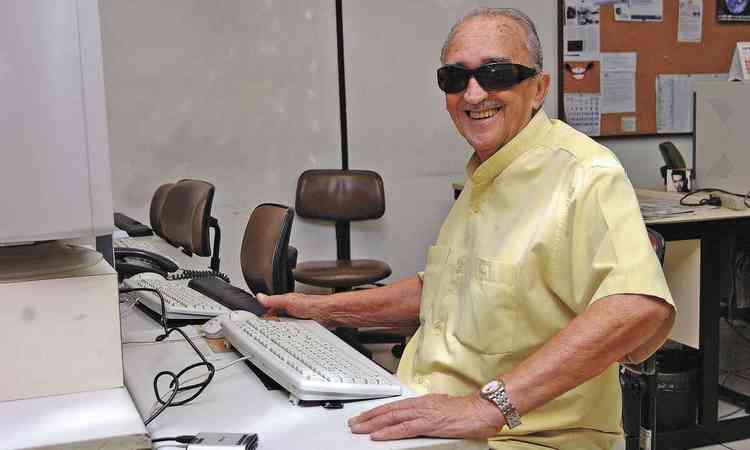 Plnio Barreto sorri sentado em frente ao computador na redao do jornal Estado de Minas
