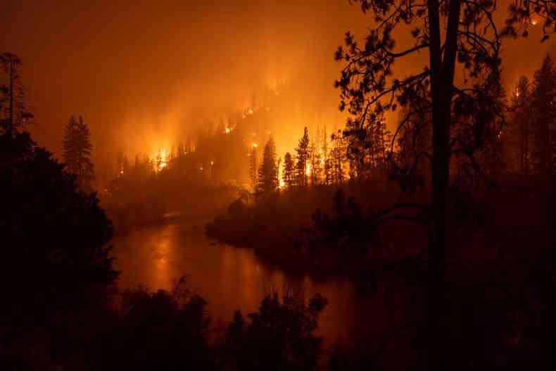 Fogo queima rvores s margens do Rio Klamath, em Parque Nacional 
